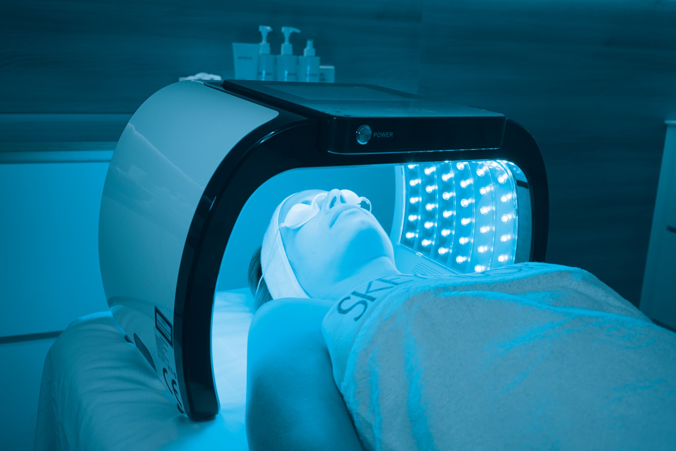 A CLEARIST CTX treatment in progress — the DermaLED canopy glowing blue over the treatment bed
